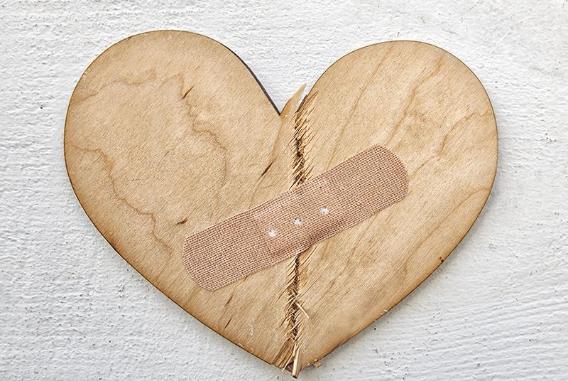 Broken wooden heart cutting board with bandaid
